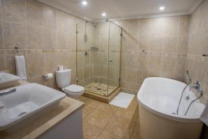 a bathroom with a shower and a toilet and a sink at Stay at The Point - Peaceful Plentiful Penthouse in Durban +22 photos