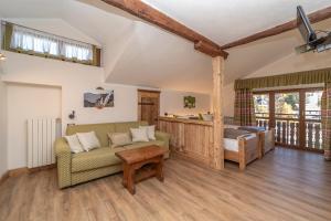 a living room with a couch and a bed at Hotel Stella Alpina in Sauze dʼOulx +77 photos