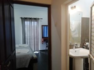 a bathroom with a bed and a sink and a mirror at Le Petit Hotel & Restaurant in Negombo