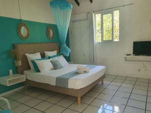 um quarto com uma cama com uma parede azul em Village Le Pre em Terre-de-Haut