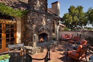 a patio with a stone fireplace in front of a house at Rancho Caymus Inn in Rutherford