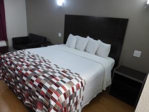 a hotel room with a large bed and a chair at Red Roof Inn Corpus Christi North - Near Downtown in Corpus Christi +17 photos