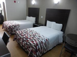 a hotel room with two beds and a table at Red Roof Inn Corpus Christi North - Near Downtown in Corpus Christi