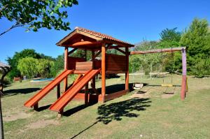 een speeltuin met een houten structuur in een park bij Quebrada del Viento - Cabañas in Los Hornillos