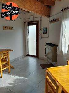 sala de estar con mesa y puerta en La Cantonada, alojamiento turístico, Caviahue en Caviahue
