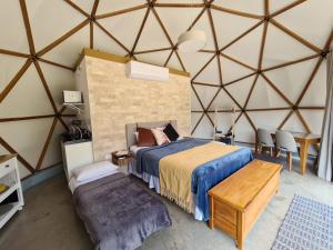 a bedroom in a yurt with a bed and a table at Domo da Cuesta - Glamping com vista para a montanha in Bofete