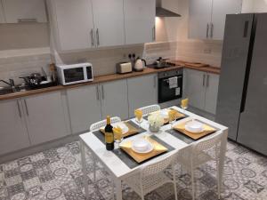 a kitchen with a white table with two chairs and a microwave at Townhouse @ 46 Nelson Street Crewe in Crewe