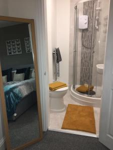 a bathroom with a shower and a toilet and a bed at Townhouse @ 46 Nelson Street Crewe in Crewe