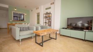 een woonkamer met een bank, een tv en een tafel bij Fuentes Duquesa B36 in Manilva