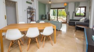 een woonkamer met een houten tafel en witte stoelen bij Fuentes Duquesa B36 in Manilva