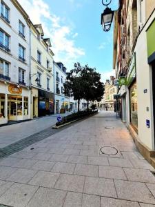 una calle vacía en una ciudad con edificios en Le Citadin chic, en Dreux
