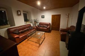 ein Wohnzimmer mit Ledersofas und einem Couchtisch in der Unterkunft SG chalupa MLÁZOVICE 1 se soukromým wellness v ceně in Mlázovice