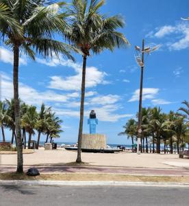 un phare au milieu d'une plage bordée de palmiers dans l'établissement Kitnet para Temporada no Litoral SP, à Praia Grande