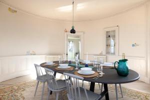 a dining room table with chairs and a blue vase at JOIVY Observatory House & Apartment in Edinburgh