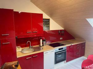 a kitchen with red cabinets and a sink at FeWo by Toni in Salzgitter