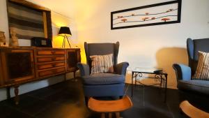 a living room with two chairs and a tv at Casa do Compadre - Casas de Taipa in São Pedro do Corval