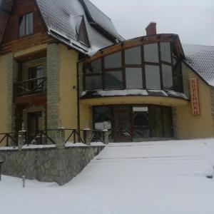 a building with snow on the ground in front of it at Садиба "Коренюки" in Tatariv