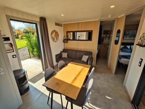 a caravan dining room and living room with a table and chairs at Domaine des graminées in Jeanménil