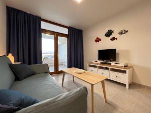 a living room with a couch and a tv and a table at Tamarán 309 in Playa del Ingles