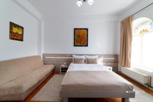 1 dormitorio con 1 cama y 1 sofá en Vila Belvedere, en Galaţi