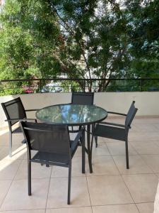 a glass table and chairs on a patio at Modern Luxury Apartment in the heart of Nicosia in Nicosia
