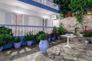 a patio with a table and a bunch of potted plants at Ilias Studios in Patitiri