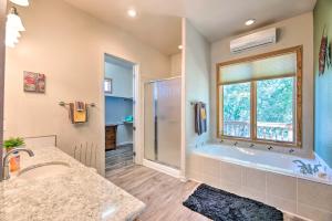 Un baño con bañera, lavabo y ventana. en Docs Retreat in Ruidoso Downs with Mtn Views, en Ruidoso Downs