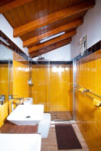 a bathroom with a sink and a shower with yellow tiles at Family Room - Quinta do Mirante in Castelo de Paiva