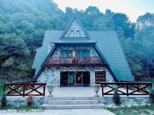 a large building with a peaked roof with a staircase at Cabana Taia in Petrila