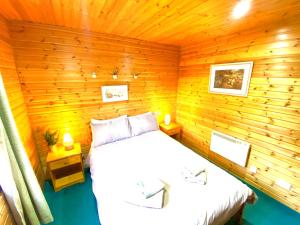 a bedroom with a bed in a wooden cabin at Braemar Lodge Cabins in Braemar