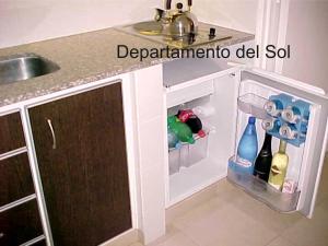 een keuken met een wastafel en een open koelkast bij Departamentos del Sol in Necochea