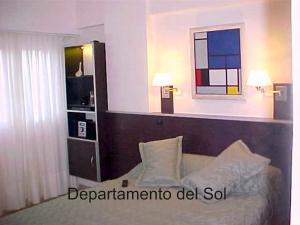 een slaapkamer met een bed, 2 lampen en een raam bij Departamentos del Sol in Necochea