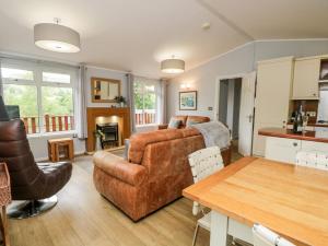 un soggiorno con divano e tavolo di Ambleside Lodge a Windermere