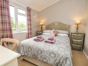 a bedroom with a bed with pink towels on it at Ambleside Lodge in Windermere