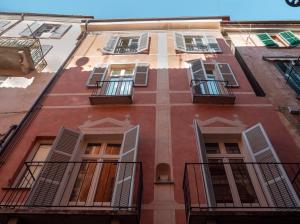 a tall red building with windows and balconies at Le Dimore di Piazza in Mondovì