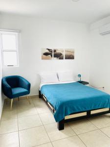 a bedroom with a bed and a blue chair at Liverté Armonia 102 in Cancún