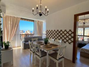 a dining room and living room with a table and chairs at Benidormflats in Benidorm