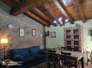 a living room with a blue couch and a table at Casa La Querola in Morella