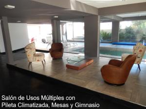 a lobby with chairs and a pool in the background at Solares de Araus 406 in Colonia del Sacramento