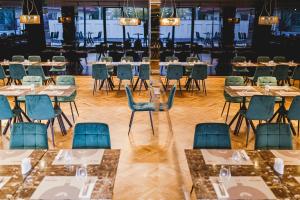- une salle à manger avec des tables et des chaises dans l'établissement Hermanns Hotel & Spa Sibiu, à Sibiu