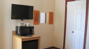 a tv sitting on top of a wooden stand in a room at Rosecourt Motel in Stratford