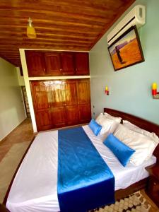 een slaapkamer met een groot bed met blauwe kussens bij L'oliveraie D'amizmiz in Amizmiz