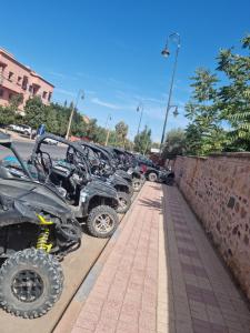 una fila de vehículos estacionados junto a una pared en L'oliveraie D'amizmiz, en Amizmiz