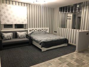 a bedroom with a bed and a window and a couch at Аpartments Central Town Містечко Центральне з власним паркінгом та документами на проживання in Ivano-Frankivsʼk