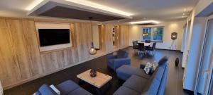 sala de estar con muebles azules y TV de pantalla plana en Upland Lounge, en Willingen