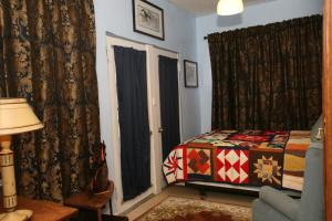 a bedroom with a bed and a couch and curtains at Spirit Tree Inn B&B in Patagonia