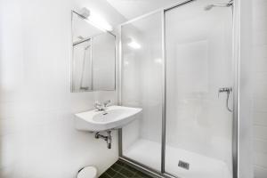 een witte badkamer met een wastafel en een douche bij Avet in El Tarter