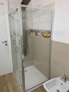a shower with a glass door next to a sink at Oasi verde in Aosta