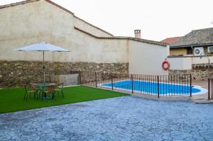 patio con tavolo, ombrellone e piscina di C - Apartamento moderno con piscina compartida a Torrico