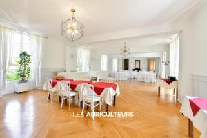 een eetkamer met een rode tafel en witte stoelen bij Hôtellerie Nouvelle de Villemartin in Morigny-Champigny